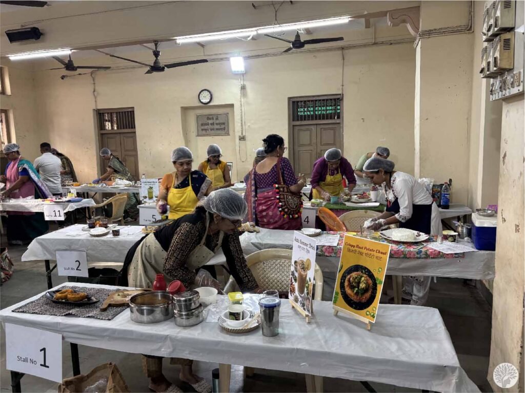 Participants at Stall 1 and Stall 5 practicing mindful cooking at home during a live culinary competition in a community hall.