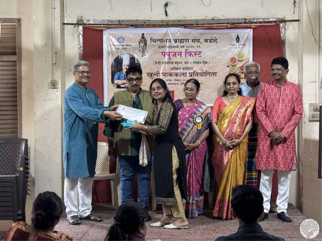Meena Patil receiving the first position award from Chef Vishnu Manohar at the Chitpavan Brahman Sangh culinary contest in Baroda.