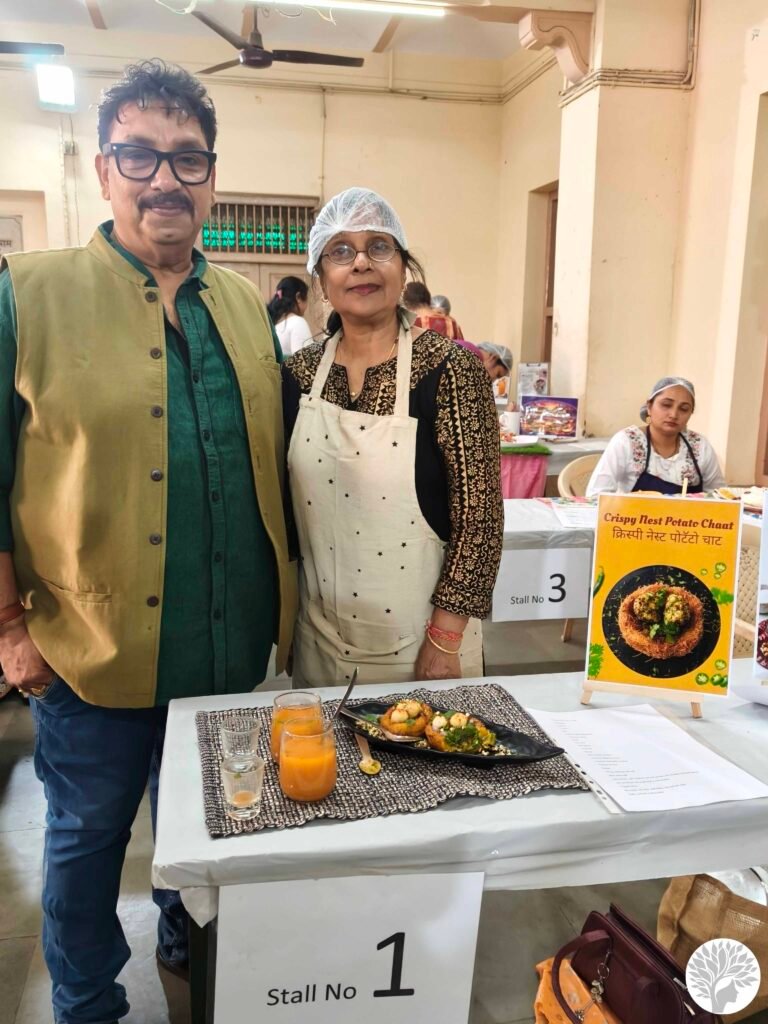 Winner Meena Patil standing with celebrity Chef Vishnu Manohar at Stall No. 1 during a mindful cooking competition in Baroda.