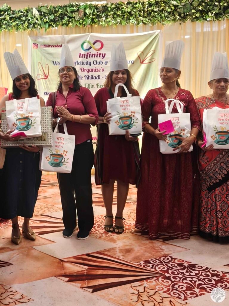The author (Token 23) and other winners standing on stage wearing chef hats and holding gift bags at the Kitchen Ke Khiladi Season 3 award ceremony.